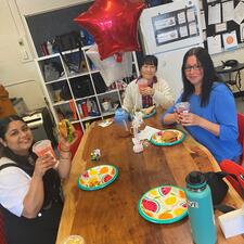 Group of support staff sitting down enjoying starbucks and treats